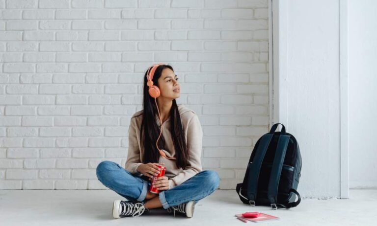 lady sitting listening to headphones holding coca cola